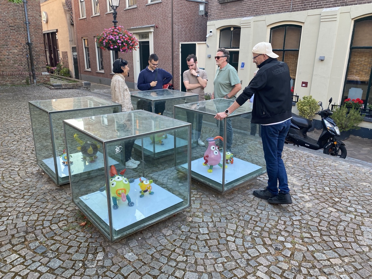 Vier kubussen met daarin een kunstwerk van glas. Het zijn mythische dieren ontworpen door kinderen. 