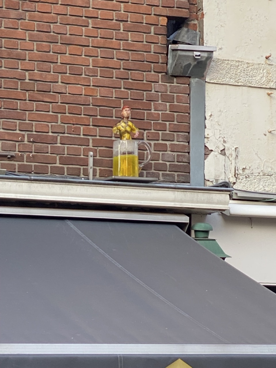 Glad ornament wat boven een café hangt. Het beeld dan ook een barvrouw op een pul bier uit. 